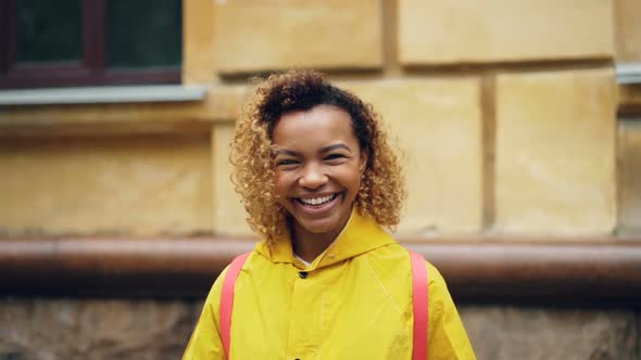 Slow Motion Portrait of Cute Mixed Race Girl with Curly Hair Looking at Camera and Smiling Standing