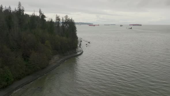 Stanley Park Seawall with oil tankers and cargo ships on the background in 4K