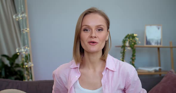 Pretty Young Woman Waving Hello and Gesturing While Recording Video for Her Beauty Vlog. Female