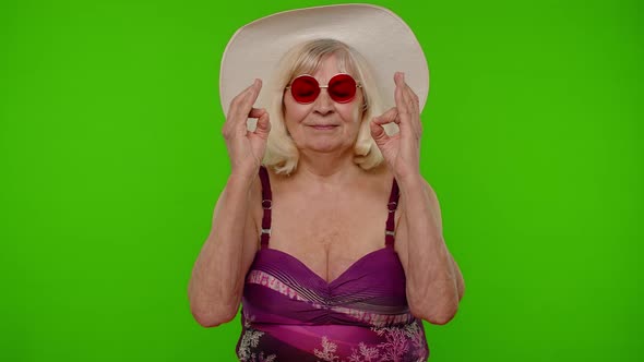 Elderly Woman Tourist in Swimsuit Relaxing Meditating Practicing Yoga Calms Down on Chroma Key