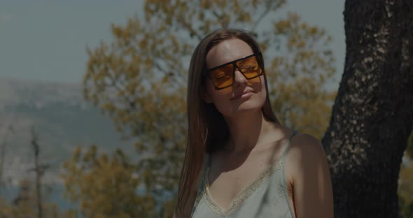 Girl in sunglasses smile on the mountains background