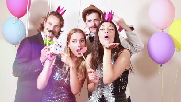 Beautiful friends having fun in party photo booth