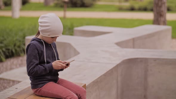 Child Is Using Mobile Phone. Kid Is Looking at Screen of Devices