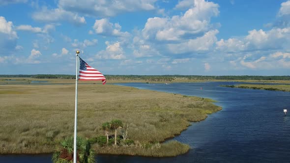 American Flag Stock Video Footage - An American Flag Swaying In A Pole Over A River Swamp