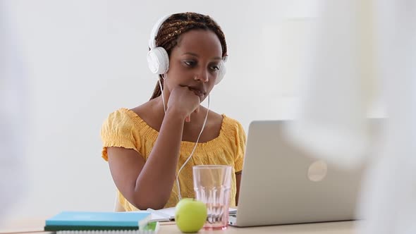 American African Woman Working Remotely and Having Online Talk at Table with Laptop at Home Spbi