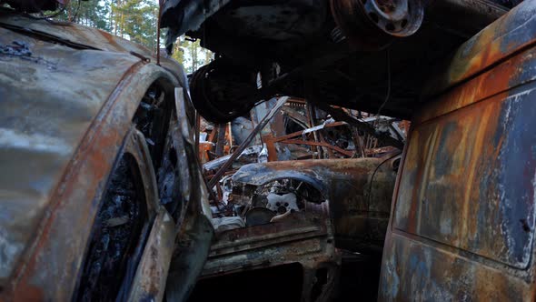 Live Camera Moves Forward Burnt Out Ruined Automobiles in Car Dump