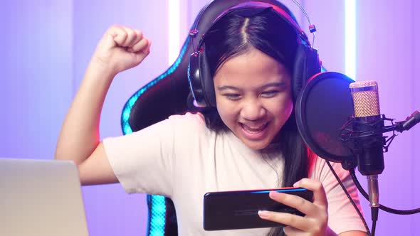 Asian Kid Girl Playing Video Game With Mobile Phone Then Celebrating While Live Stream