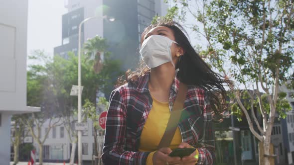 Mixed race woman wearing medical coronavirus mask on the street