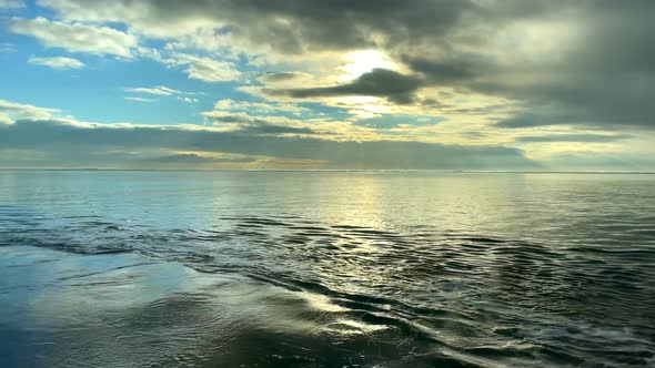 Slow motion picturesque ocean view during sunlight hiding behind cloudscape during daytime - No Peop