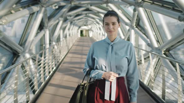 Young Chic Business Woman Standing At Glass Bridge