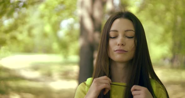 Close-up Portrait of a Cute Brunette Girl with Straight Hair, She Fooling Around