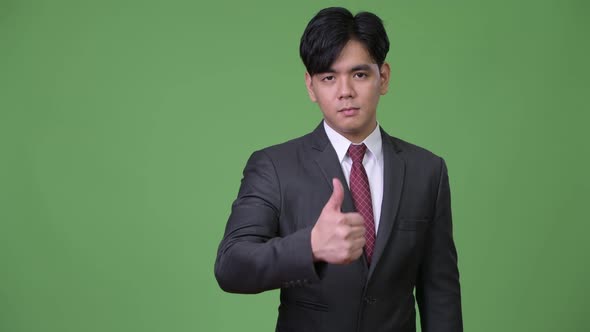 Young Handsome Asian Businessman Giving Thumbs Up
