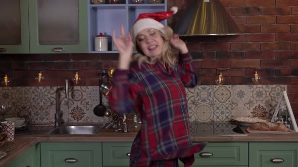 Happy Christmas Cheerful Woman Dancing at Home in Santa Claus Hat