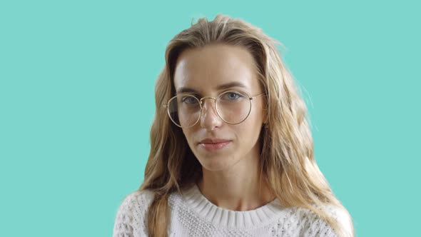 Portrait of Clever Girl in Eyewear Looking at a Camera in a Blue Screen Background. A Smart Teenager