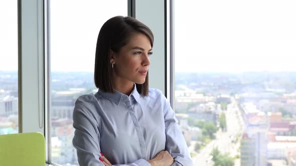 Happy Businesswoman Looking Through Window at Modern Office Enjoy Successful Day and Smiling