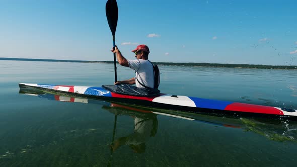 A Man Is Drifting Along the River in a Kayak