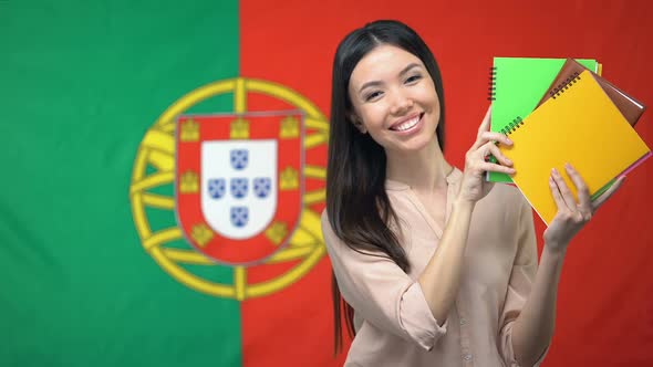 Woman Holding Copybooks Against Portuguese Flag Background, Learning Language