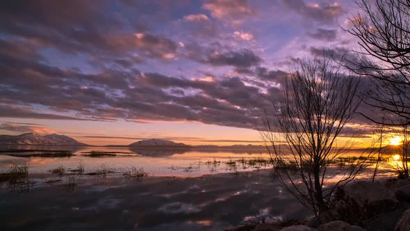 Time lapse of the sunset setting reflecting the color of the sky in Utah Lake