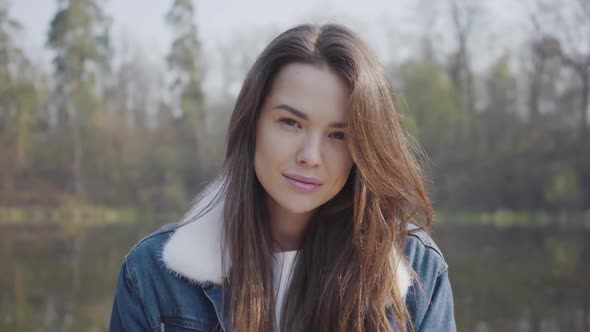 Portrait of Pretty Young Smiling Woman Looking in the Camera. Beautiful Landscape, River on