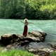 Young beautiful vintage woman in long skirt and straw hat dancing on stones near mountain river - VideoHive Item for Sale