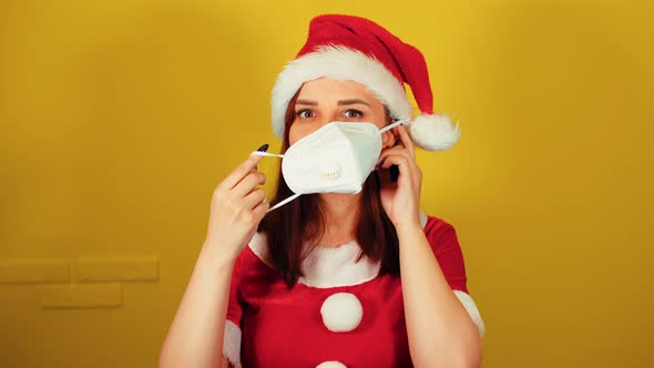 Woman in Santa Costume Puts Medical Mask on Face