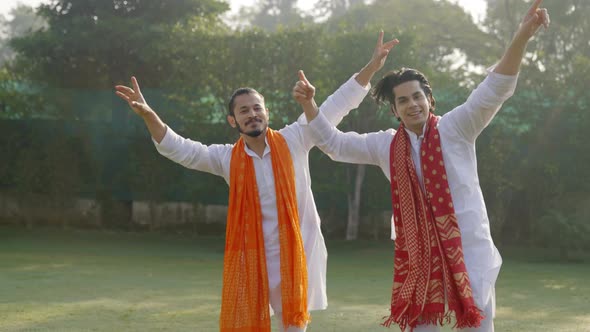 Indian men dancing and doing the bhangra in an Indian traditional outfit Kurta Pajama