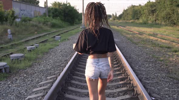 Young Happy Free Woman Walking and Dancing Along the Railway Track