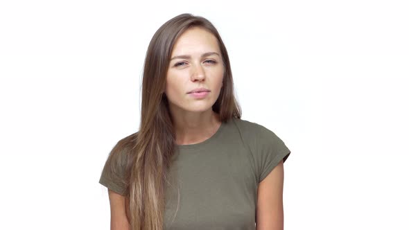 Lady with Long Brown Hair Expressing Disgust Saying No with Facial Expresions Over White Background