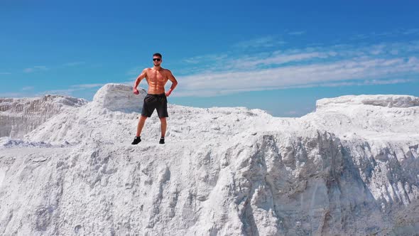 Professional bodybuilder posing. Concept of sport outdoors. Aerial view.