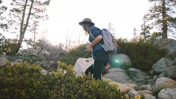 Young Beautiful Local Girl with Backpack and Camera Hiking Alone, Climbing Big Rocks at Yosemite