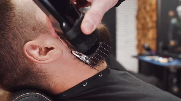 Beard Cutting on Cheeks with Shaving Machine Closeup