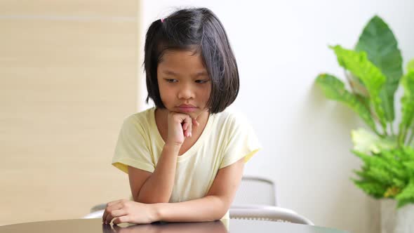 Portrait of Asian child 5 year old and to collect hair and Place her hands on her chin and make thin