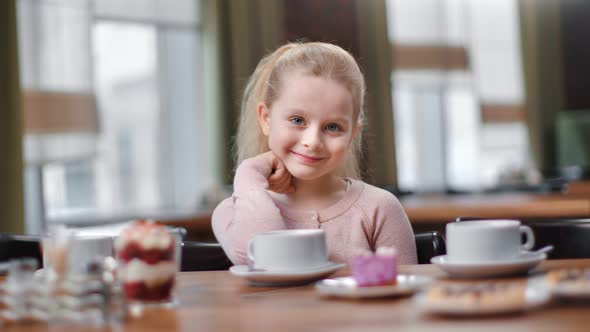 Pleasant Little Kid Smile Sitting at Cafeteria