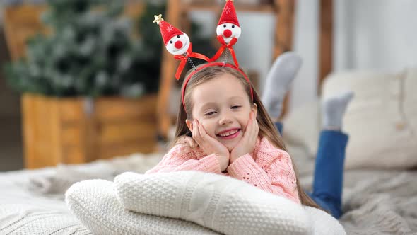 Playful Smiling Cute Girl Wearing Funny Festive Ears Rejoicing Holiday Looking at Camera