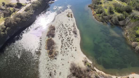 Aerial footage of a flowing river with green banks