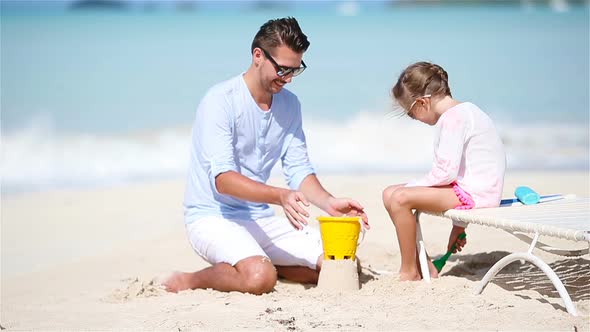 Father and Little Kid Making Sand Castle at Tropical Beach