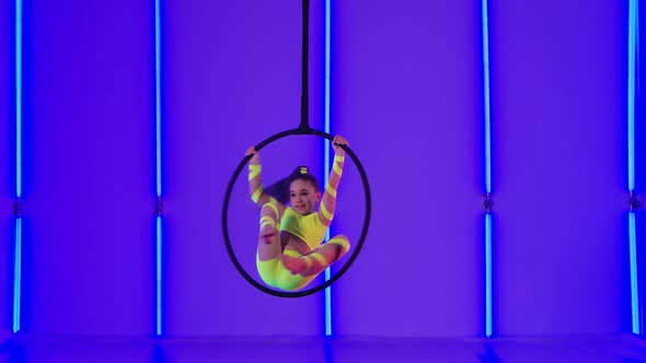 Young Aerial Gymnastic Perform Acrobatic Stunts on an Air Hoop