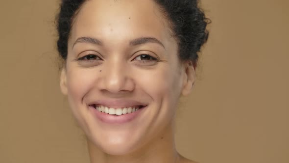 Beauty Portrait of Young African American Woman with Healthy Skin Looking at Camera and Smiling