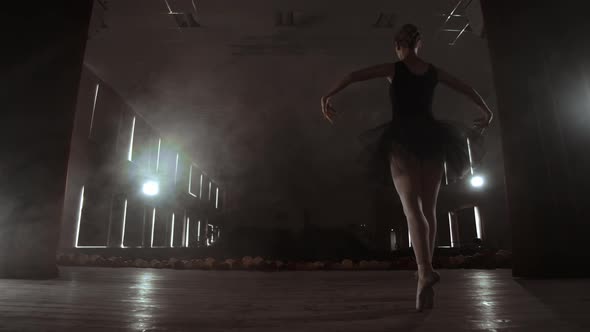 Slow Motion the Prima Ballerina in a Black Dress Performs Rotations and Graceful Dance Moves