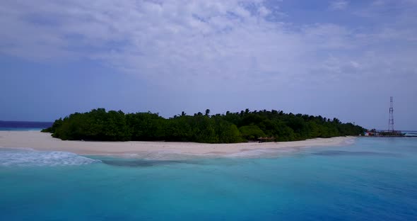 Tropical overhead travel shot of a sandy white paradise beach and aqua turquoise water background in