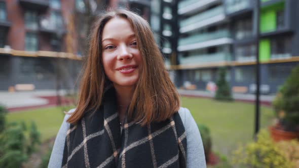 Portrait of a Gorgeous Dark Haired Woman Smiling Charmingly While Standing Against the Background of