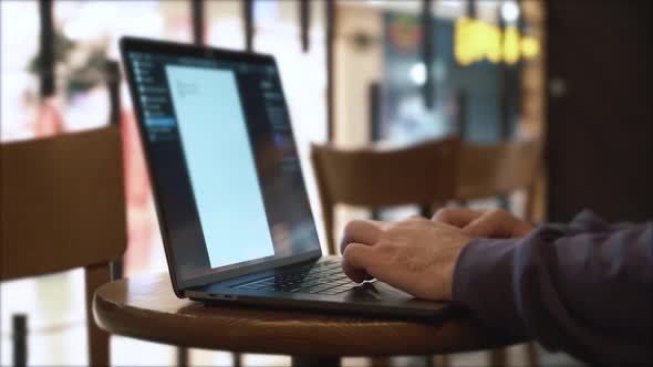 Man Working on Laptop in a Coffee Shop