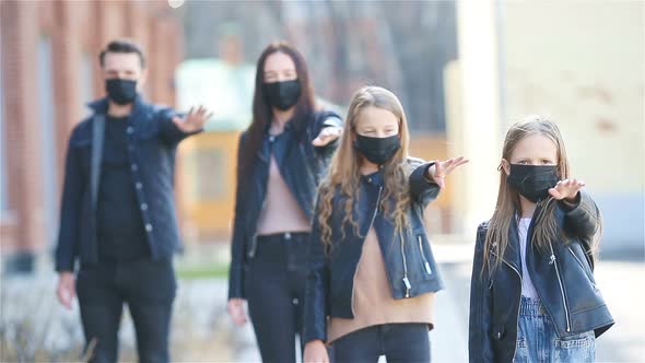 Family Wearing a Mask on a Background of a Modern Building,