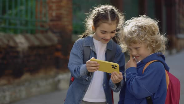 Happy Classmates Watching Funny Video on Smartphone on the Street