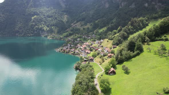 Blue lake and small Swiss village drone view mountains and nature.