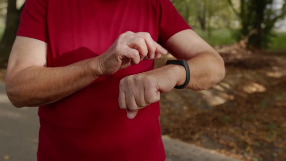 Senior Old Runner Man Starting Tapping Touchscreen on Smart Watch, Tracking Distance, Checking Pulse