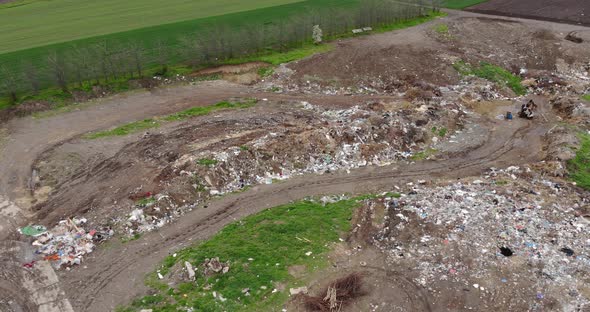 Abandoned Structures Next To A Garbage Hill On Landfill And Workers In Not Recycling Trash. - Aerial