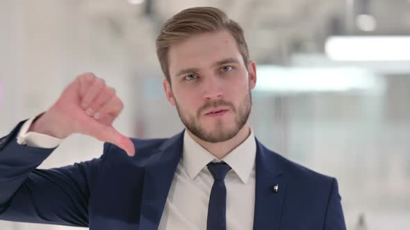 Thumbs Down Gesture By Young Businessman