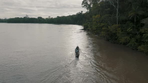 Aerial shot of boat sailing in the river. Small boat with local people on the Javari River, Amazon b