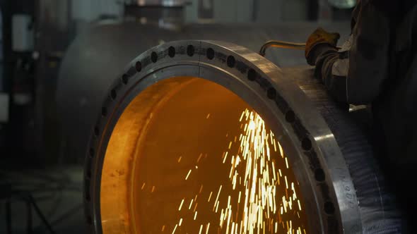 Work Grinder Cuts Metal at the Factory. Heavy Industry Worker Cuts a Huge Pipe